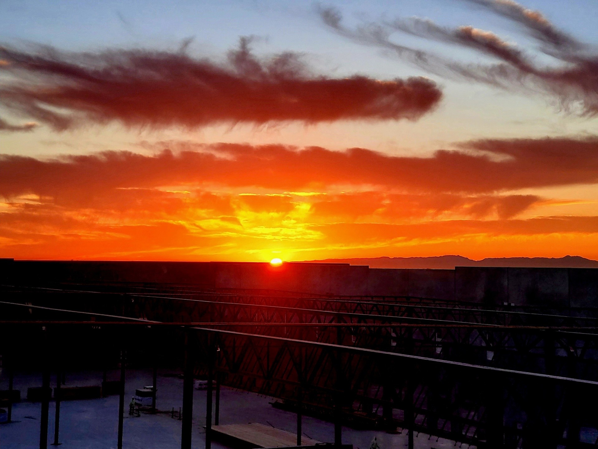 Ironworkers welding structural steel at sunset on a Phoenix commercial jobsite